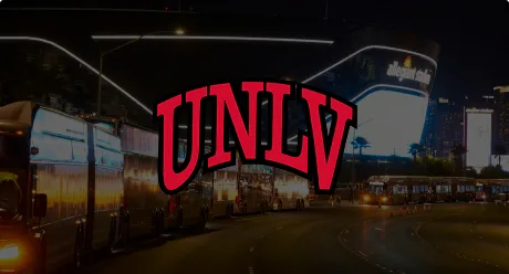 The red UNLV logo is centered over a nighttime scene with buses lined up along a street, and illuminated buildings in the background.