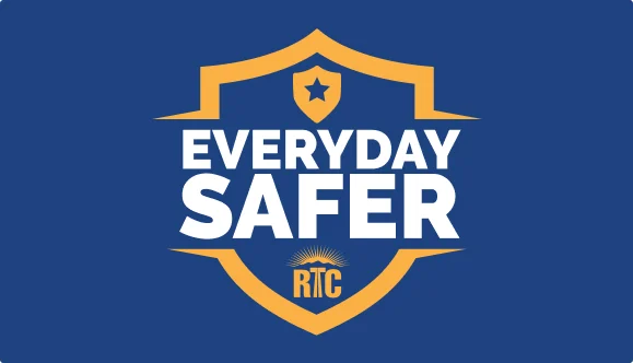 A blue shield with a gold outline and a star at the top contains the words EVERYDAY SAFER in bold white letters and the RTC logo with a rising sun at the bottom.